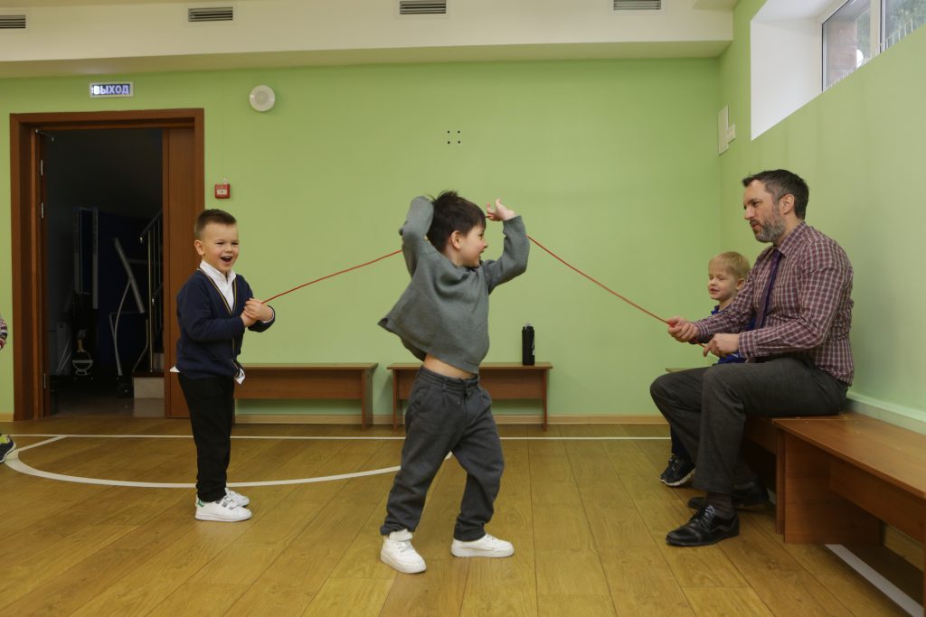 Педагог и дети на занятии в спортивном зале Riverside / A teacher and children during an activity in the Riverside sports hall