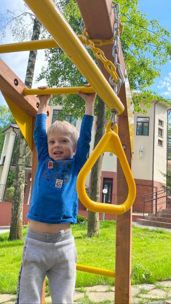Ребёнок на гимнастических кольцах на площадке Riverside / A child using rings in the Riverside playground