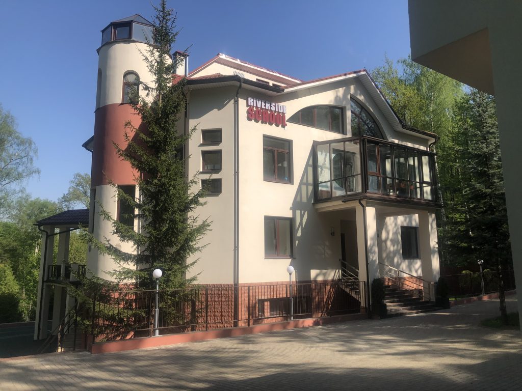 Здание Riverside School среди деревьев в Новогорске / Riverside School building among trees in Novogorsk